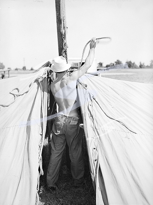 Rear view of carnival crew member at work, Lasses-White traveling show, Sikeston, Missouri, USA, Russell Lee, U.S. Farm Security Administration, May 1938