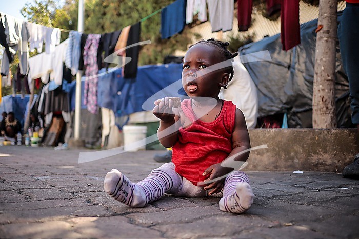 TUNIS, TUNISIA, An African migrant baby sits at a street in Tunis. African migrants who arrived in Tunisia illegally take shelter at a street 200 meters from the International Organization for Migration (IOM) building in Tunis, Tunisia on March 18, 2024.. African migrant camp in Tunisia