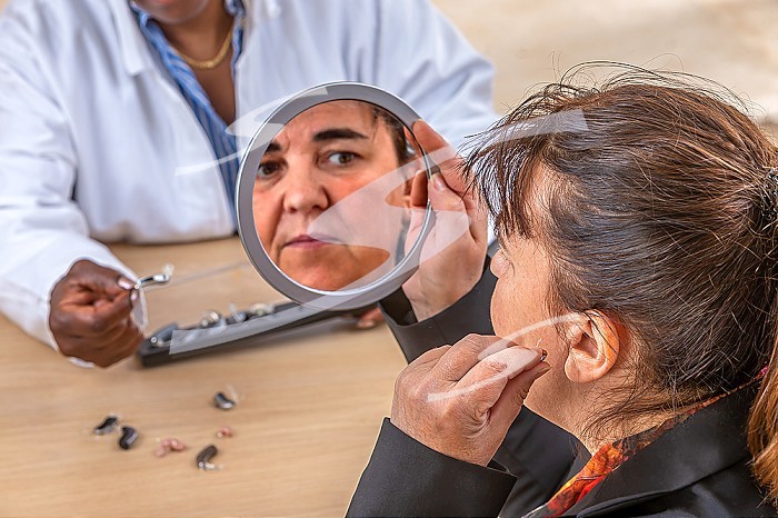 Patient trying different types of hearing aids.
