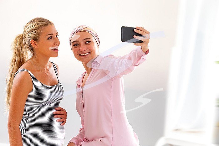 Two young women in the hospital taking a selfie during a visit