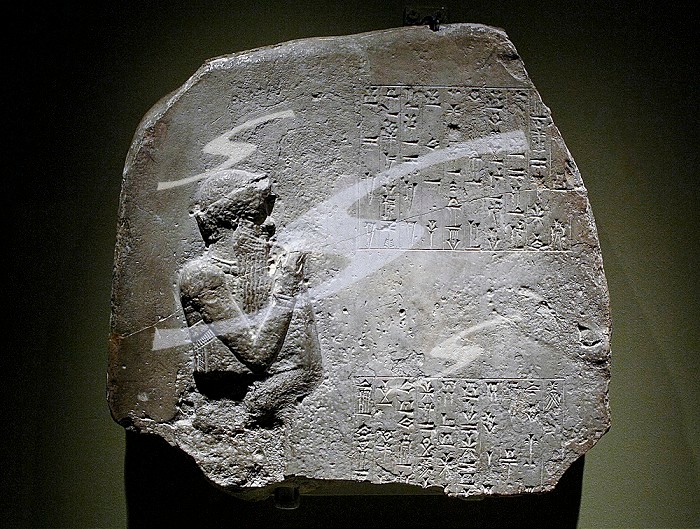 Votive offering. Fragment of a stone stele dedicated by Itur-Ashdum. First Dynasty of Babylon, c. 1760-1750 BC. Probably from Sippar, southern Iraq. Limestone. The cuneiform inscription states that a high official called Itur-Ashdum dedicated a statue to the goddess Ashratum in her temple, on behalf of King Hammurabi (reigned 1792-1750 BC). The figure carved may represent  Hammurabi. British Museum. London, England, United Kingdom.. Fragment of a stele dedicated by Itur-Ashdum.